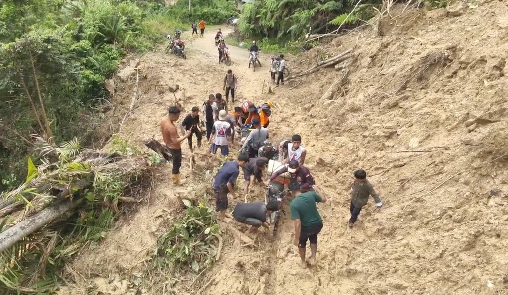 Petugas berupaya melewati jalan yang tertutup longsor untuk menyalurkan bantuan kepada warga terdampak banjir bandang dan longsor di Kampung Langgai, Nagari Gantiang Mudiak Utara Surantih, Kecamatan Sutera, Pesisir Selatan, Sumatera Barat, Minggu (10/3/2024).