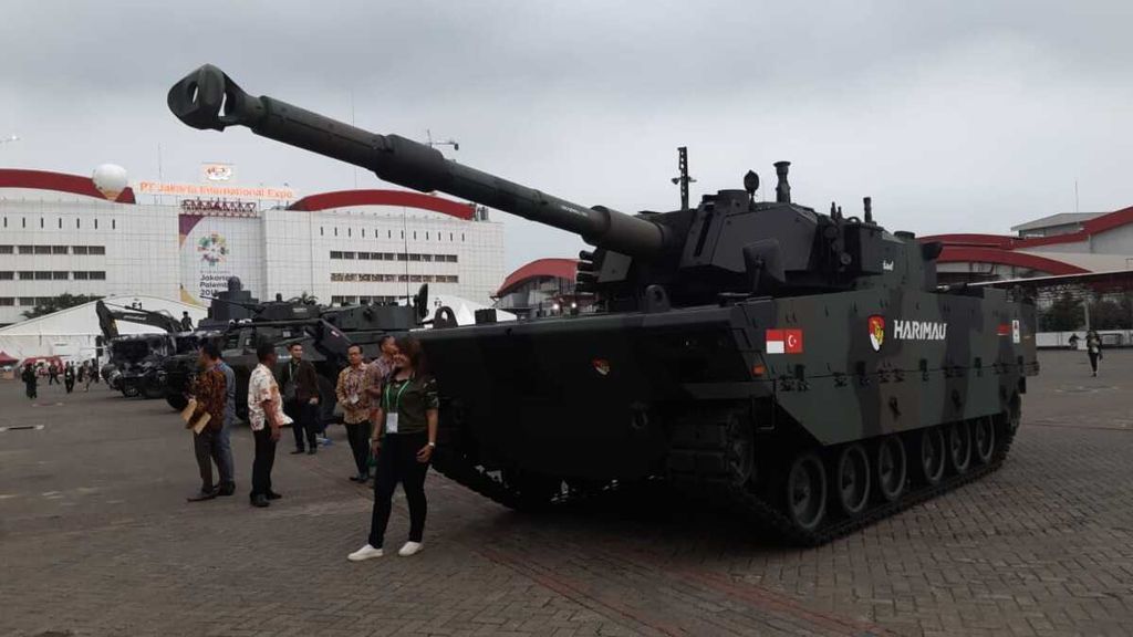 Pengunjung Indo Defence 2018 Expo and Forum berfoto di depan Tank Harimau di lapangan Jakarta International Expo, Kemayoran, Jakarta Pusat, Jumat (9/11/2018).