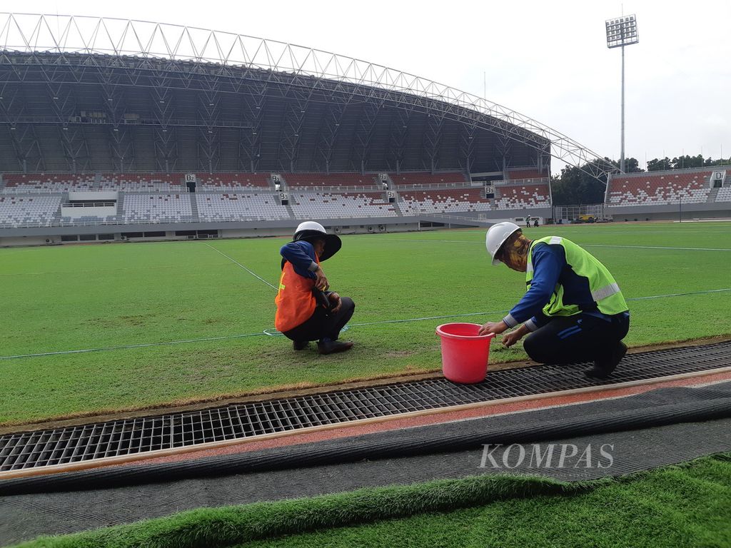 Dua pekerja sedang mencabut rumput di Stadion Gelora Sriwijaya di Kompleks Jakabaring Sport City, Palembang, Sumatera Selatan, Kamis (9/3/2023). Stadion ini akan menjadi saah satu tempat pertandingan untuk perhelatan Piala Dunia FIFA U-20 pada Mei 2023.