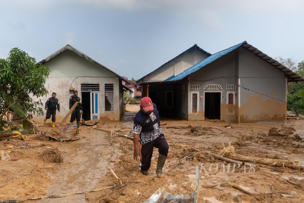 Warga melewati lumpur di Kampung Genting, Desa Pangkalan, Kecamatan Serasan, Kabupaten Natuna, Kepulauan Riau, Kamis (9/3/2023). Longor di lokasi tersebut menghancurkan 27 rumah warga. 