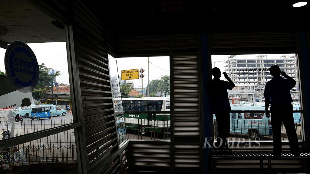 Pekerja membersihkan  halte transjakarta di Kampung Melayu, Minggu (28/5), pasca bom bunuh diri pada Rabu lalu. Menurut rencana, hari ini, Senin (29/5), halte tersebut akan kembali digunakan untuk melayani penumpang.