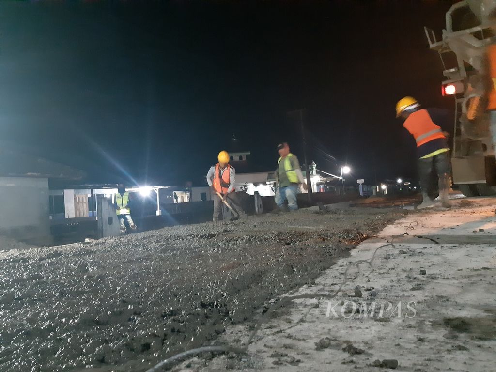 Para pekerja sedang melakukan pekerjaan pembetonan jalan di ruas jalan Kota Gajah-Seputih Raman-Simpang Randu pada Kamis (26/10/2023) malam. Ruas tersebut merupakan salah satu ruas jalan yang sedang diperbaiki menggunakan dana APBN senilai Rp 800 miliar. 