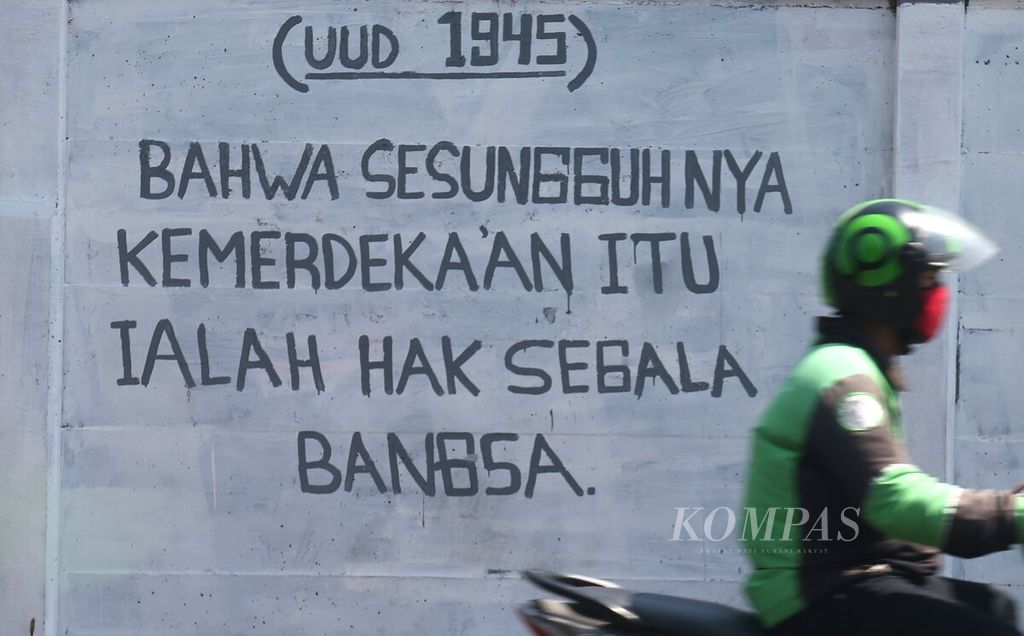 Mural yang berisi salah satu petikan Pembukaan Undang-Undang Dasar (UUD) 1945 tergambar di Jalan Raya Bogor, Depok, Jawa Barat, Rabu (28/7/2021). UUD 1945 merupakan hukum dasar tertulis yang disahkan oleh PPKI pada 18 Agustus 1945. UUD 1945 merupakan sumber hukum tertinggi yang melandasi seluruh produk hukum di Indonesia. 
