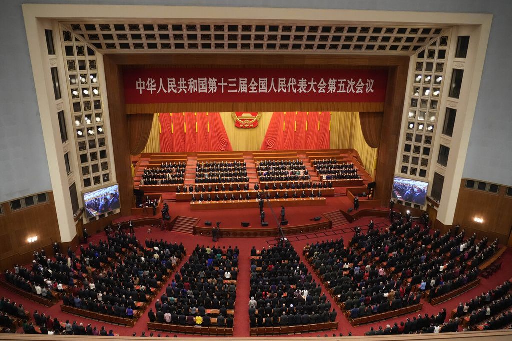 Para delegasi berdiri untuk menyanyikan lagu kebangsaan saat upacara penutupan Kongres Partai Komunis China di Aula Besar Rakyat di Beijing, 11 Maret 2022. 