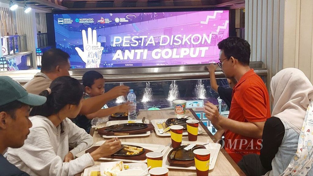 Pengunjung bersantap di salah satu restoran dengan latar monitor informasi diskon menyambut Pemilu 2024 di Mal Grand Indonesia, Jakarta, Rabu (14/2/2024). 