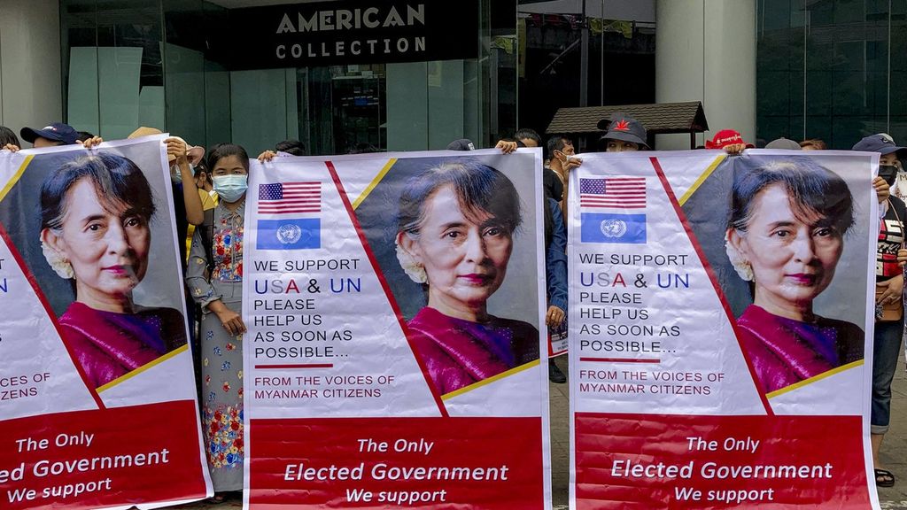 Demonstran membawa poster pemimpin Myanmar Aung San Suu Kyi saat berunjuk rasa menentang kudeta militer di Yangon, Myanmar Kamis (18/2/2021). Demonstrasi terus terjadi di Myanmar meskipun ada peringatan dan ancaman pembubaran oleh militer.
