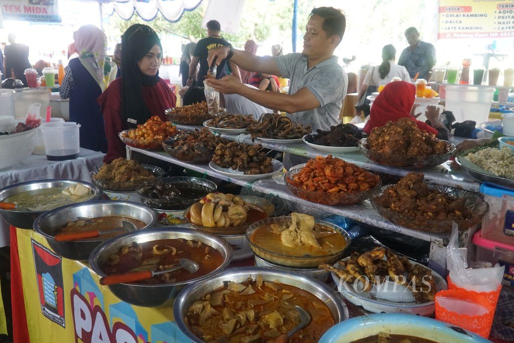 Pedagang masakan kapau sedang melayani pembeli di pasa pabukoan di pelataran parkir Ruang Terbuka Hijau Imam Bonjol, Kota Padang, Sumatera Barat, Selasa (26/3/2024) sore. 