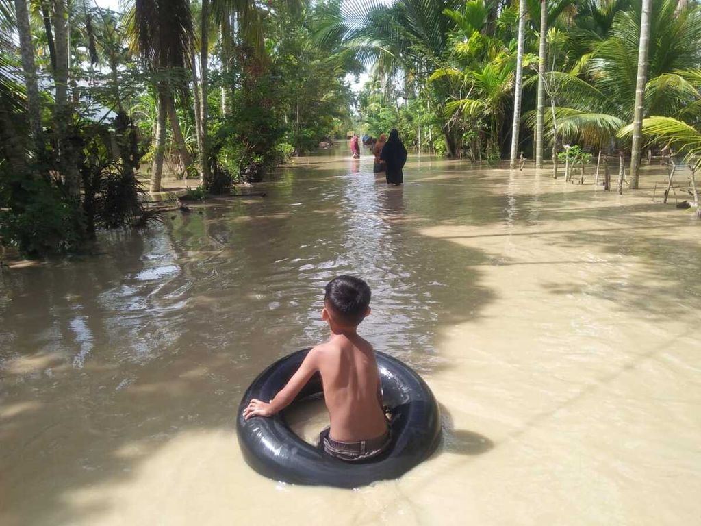 Kawasan penduduk di Kabupaten Aceh Utara, Provinsi Aceh, Rabu (5/10/2022), tergenang banjir. Warga mengalami kerugian besar karena sumber pendapatannya rusak diterjang banjir. Pelayanan publik terganggu dan anak-anak kehilangan ruang bermain.