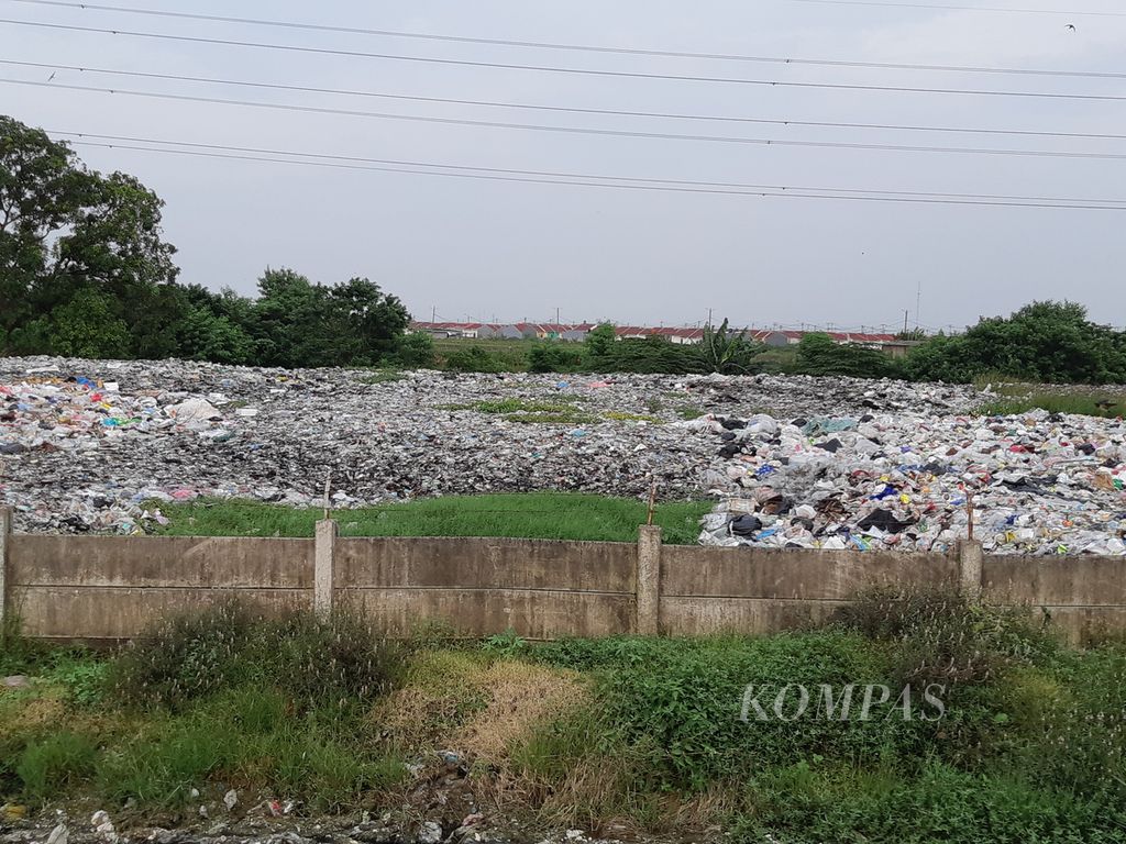 Kondisi tumpukan sampah yang diapit proyek Tol Cibitung Cilincing dan Kali Cikarang Bekasi Laut, di Desa Sumberjaya, Tambun Selatan, Kabupaten Bekasi,  Selasa (25/1/2022) sore.