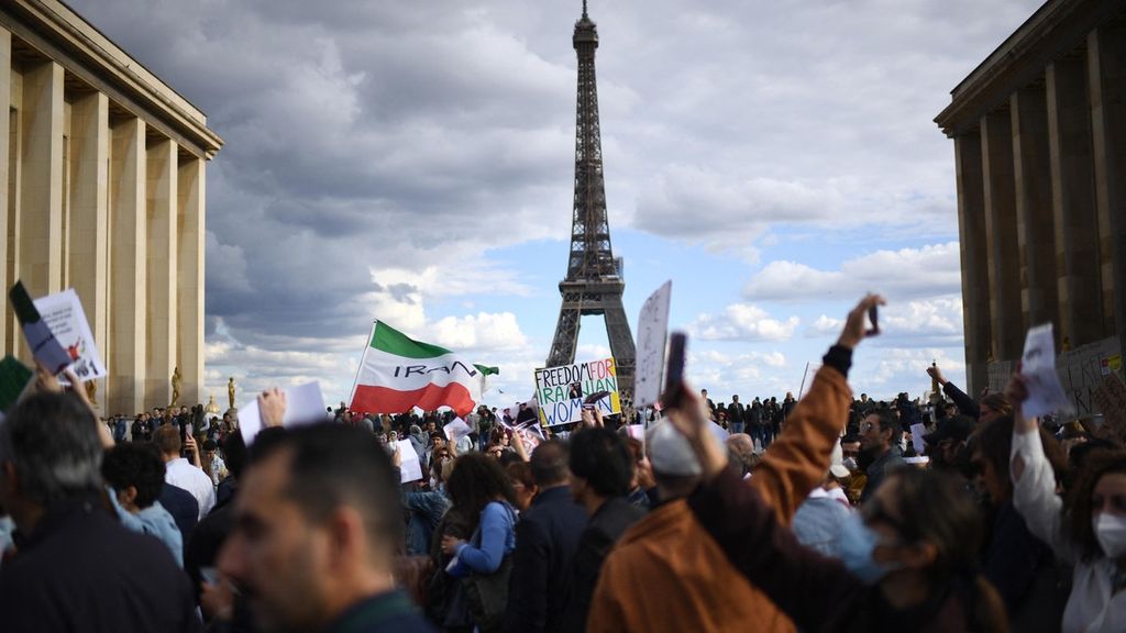 Orang-orang mengambil bagian dalam demonstrasi untuk mendukung pengunjuk rasa Iran di Trocadero, dekat menara Eiffel, Paris, Perancis, Minggu (25/9/2022) waktu setempat. 