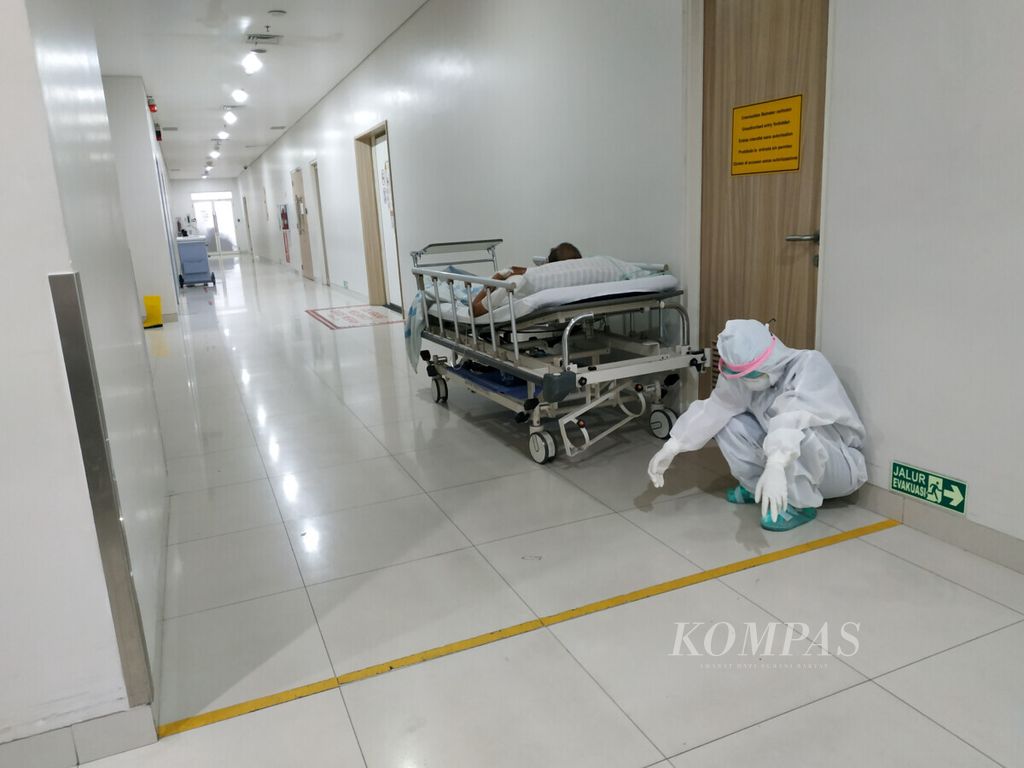 Seorang perawat beristirahat sejenak ketika melaksanakan <i>screening</i> (penyaringan) Covid-19 terhadap pasien di sebuah rumah sakit di Medan, Sumatera Utara, Rabu (23/9/2020). Perawat menjadi garda terdepan penanganan Covid-19. Sebanyak 2.983 perawat positif Covid-19 dan 85 meninggal berdasarkan data yang dihimpun di empat provinsi. Di seluruh Indonesia diperkirakan jauh lebih besar.