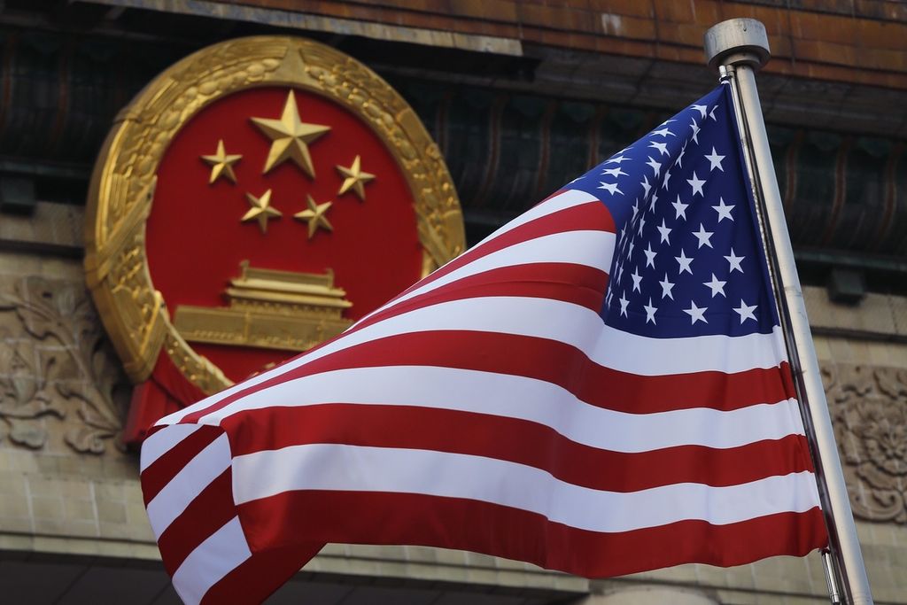 Foto dokumentasi bertanggal 9 November 2017 ini memperlihatkan bendera Amerika Serikat berkibar di dekat lambang nasional China dalam upacara penyambutan kunjungan Presiden AS Donald Trump di luar Gedung Balai Agung Rakyat, Beijing, China.