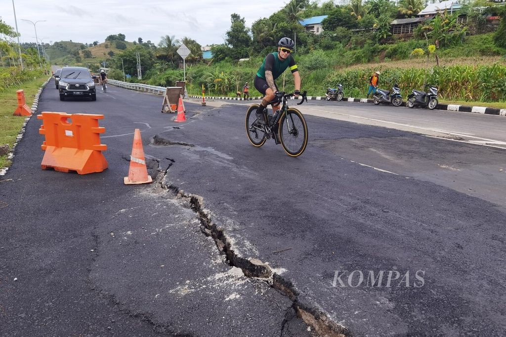 Dua pebalap WSBK dari Petronas Mie Racing Honda Team, Eric Granado (depan) dan Hafizh Syahrin (belakang), bersepeda melintasi jalan yang rusak di Kilometer 11 Jalan Bypass Bandara Internasional Lombok-Mandalika (arah bandara) di Desa Pengengat, Pujut, Lombok Tengah, Nusa Tenggara Barat, Selasa (28/2/2023). Jalan tersebut sempat ambles dan diperbaiki, tetapi rusak kembali dengan retakan sepanjang 24 meter. Jika tidak segera diperbaiki, jalan itu akan sangat membahayakan pengguna, terutama saat ajang WSBK berlangsung pada 3-5 Maret 2023 ini.