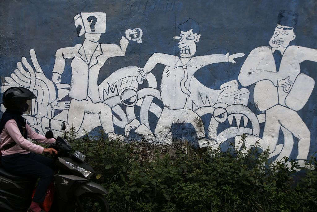 A motorbike driver passes in front of a mural with the theme of law enforcement in the Setu area, South Tangerang, Banten, Tuesday (1/2/2022). One of the pillars of democracy is how to ensure that law enforcement institutions work more fairly, do not discriminate, and protect their citizens.