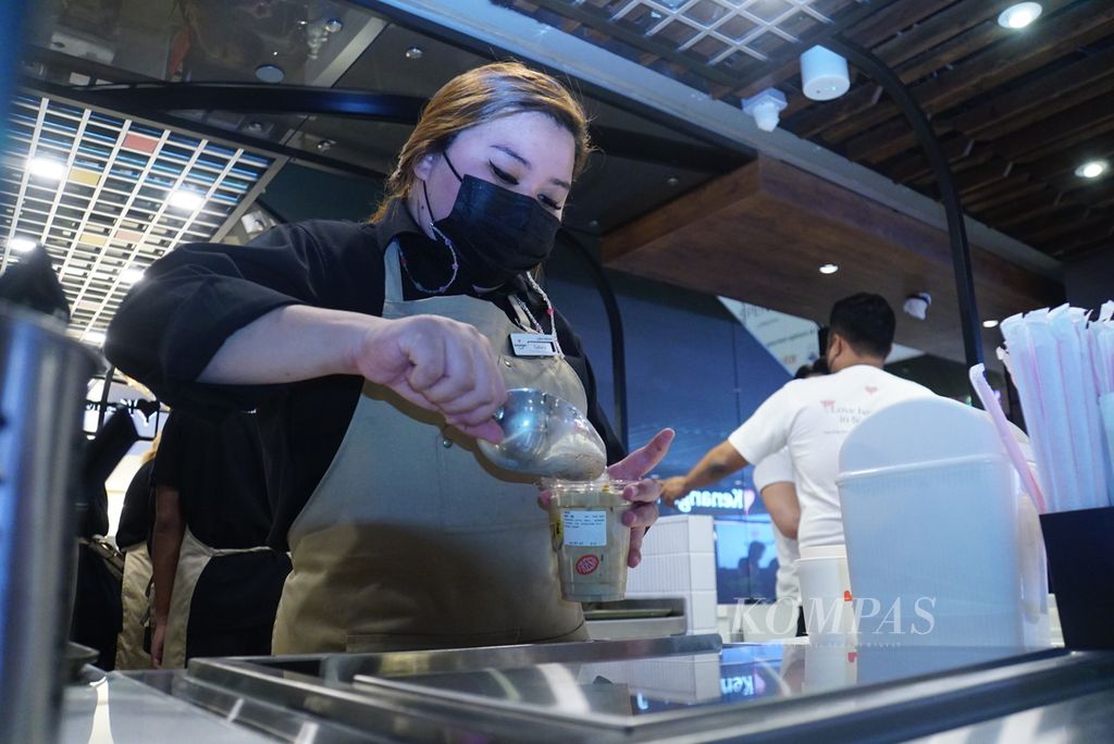 Seorang barista menyiapkan minuman di gerai pertama Kenangan Coffee yang dibuka di lantai B1 mal Raffles City di daerah pusat kota Singapura, Selasa (26/9/2023). Kehadiran Kenangan Coffee di Malaysia dan Singapura telah memberikan pekerjaan kepada lebih kurang 200 orang.