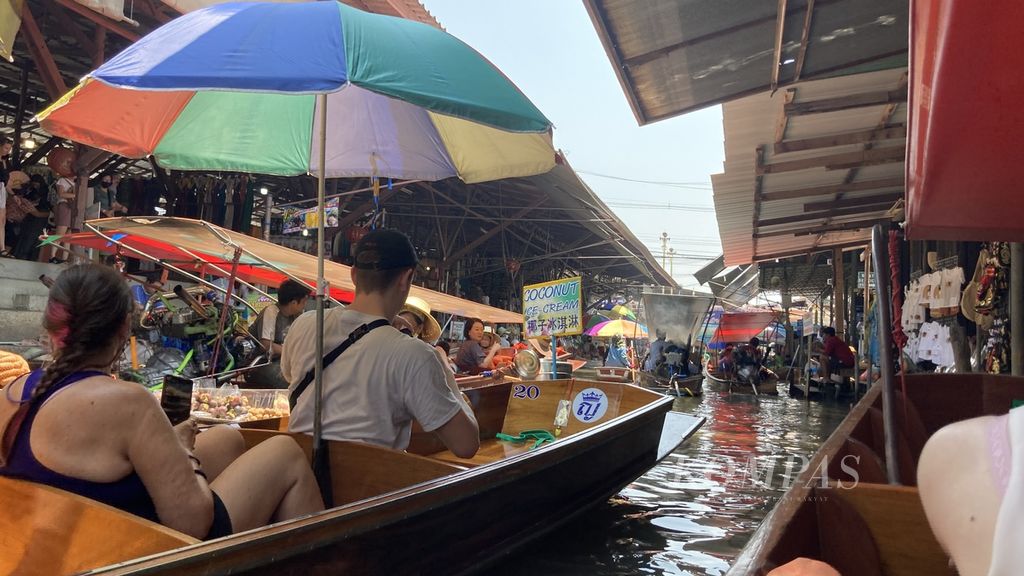 Seorang pengunjung menaiki perahu menuju Pasar Terapung Damnoen Saduak di Provinsi Ratchaburi, Thailand, Senin (27/3/2023). Pasar ini muncul setelah Raja Rama IV memerintahkan pembuatan kanal yang menghubungkan Sungai Mae Klong dengan Sungai Tha Chin sekitar 160 tahun lalu. 