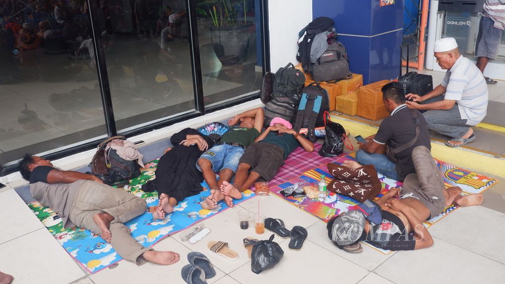 Beberapa pemudik tertidur saat menunggu jadwal keberangkatan kapal di Terminal Penumpang Bandarmasih, Pelabuhan Trisakti, Banjarmasin, Kalimantan Selatan, Minggu (16/4/2023). 
