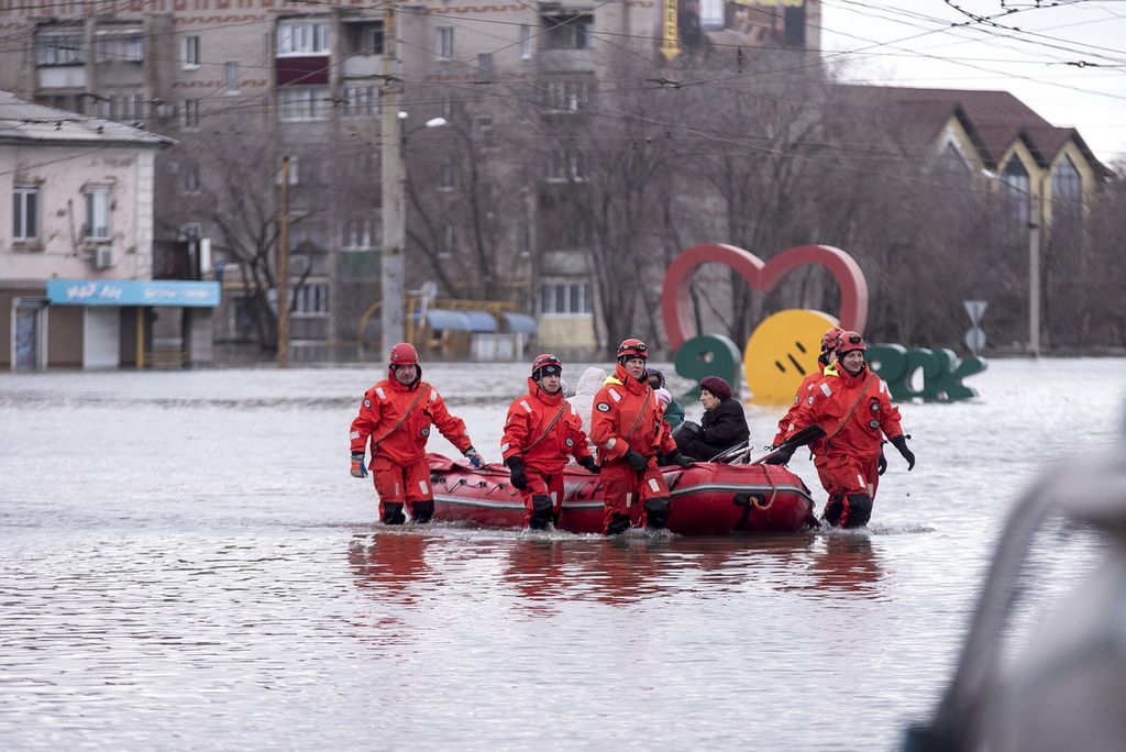 Petugas penyelamat menggunakan perahu untuk mengevakuasi penduduk setempat akibat banjir di Orsk, Rusia, 8 April 2024. 