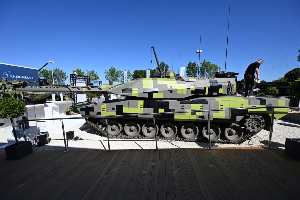 Anggota staf berdiri di atas tank KF51 dari produsen senjata Jerman, Rheinmetall, di pameran perdagangan pertahanan dan keamanan darat dan udara internasional Eurosatory, di Villepinte, pinggiran utara Paris, Perancis, Senin (13/6/2022). 