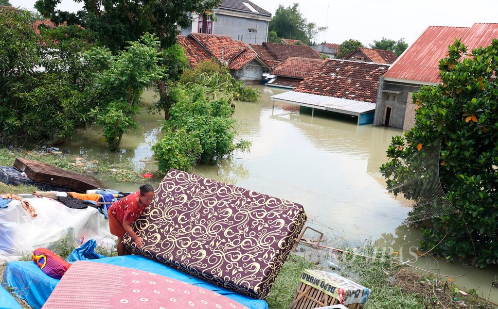 Warga menjemur  kasur di sekitar pengungsian setelah jebolnya tanggul Sungai Wulan beberapa hari lalu yang mengakibatkan banjir besar di Kecamatan Karanganyar, Kabupaten Demak, Jawa Tengah, Senin (12/2/2024). 