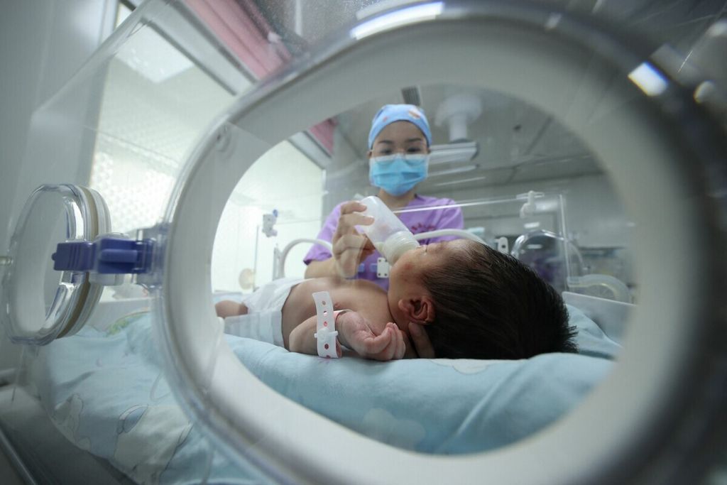 Seorang tenaga kesehatan memberikan susu kepada seorang bayi di rumah sakit di Danzhai, Provinsi Guizhou, China, 11 Mei 2011. 