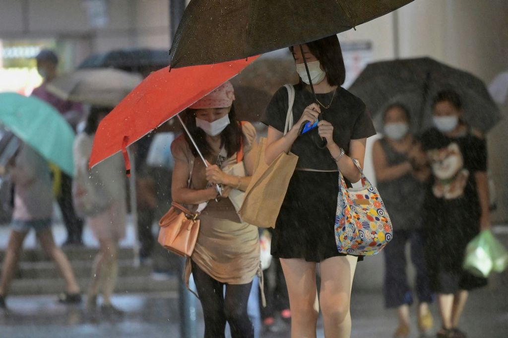 Warga berjalan di tengah guyuran hujan, di New Taipei City, Taiwan, saat badai Hinnamnor mendekati wilayah itu, 3 September 2022. 