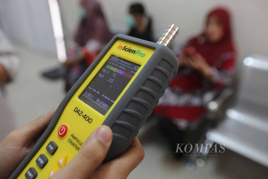Petugas Sanitarian Puskesmas Harapan Mulya, Kota Bekasi, Jawa Barat, mengukur partikel debu dengan alat <i>particle counter</i> di ruang tunggu pasien, Rabu (7/9/2023). 
