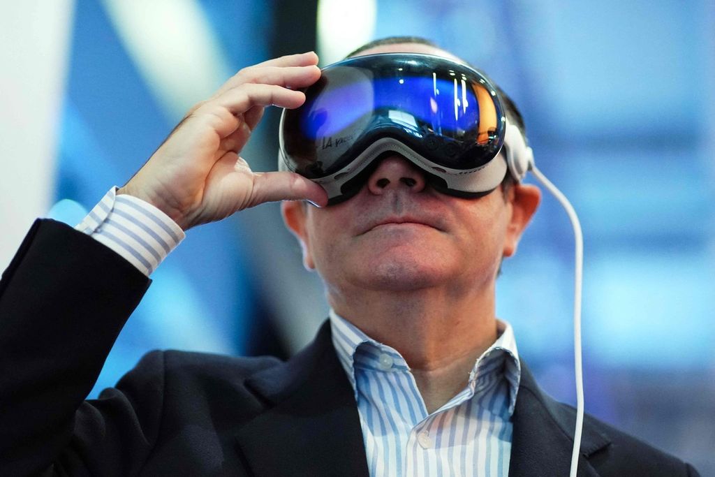 Gawai Apple Vision Pro yang menghasilkan realitas virtual dipakai seorang pria di ajang Mobile World Congress (WMC) di Barcelona, Spanyol, 27 Februari 2024. Apple Vision Pro diproduksi oleh perusahaan teknologi asal Amerika Serikat, Apple Inc. 