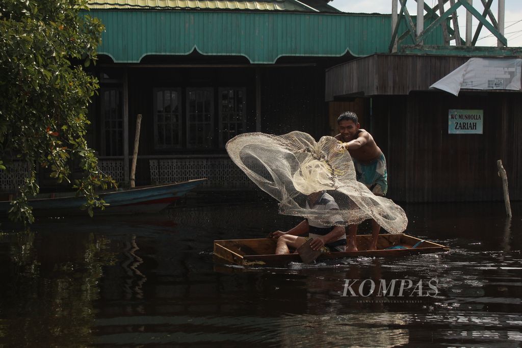 Ilustrasi-Warga menebar jaring di depan mushala yang terendam banjir di Kampung Sega, Selasa (1/11/2022). Banjir di kabupaten itu hinngga kini belum juga surut. Warga memanfaatkan banjir untuk mencari ikan.