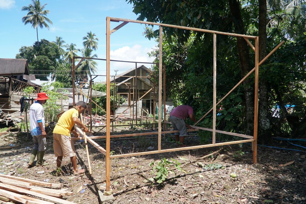Tukang mendirikan kerangka rumah hunian sementara (huntara) yang dibangun PMI Pasaman Barat bagi penyintas gempa di Jorong Tanjung Beruang, Kabupaten Pasaman Barat, Sumatera Barat, Jumat (11/3/2022).