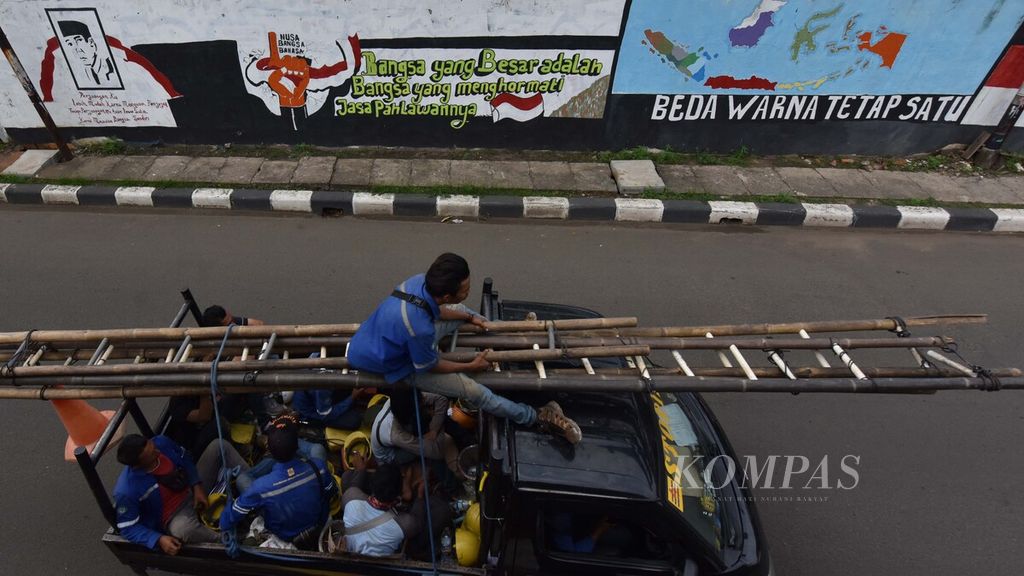 Warga melintasi deretan mural bertema nasionalisme di Jalan Jenderal Basuki Rahmat, Jatinegara, Jakarta Timur, Senin (13/1/2019). 