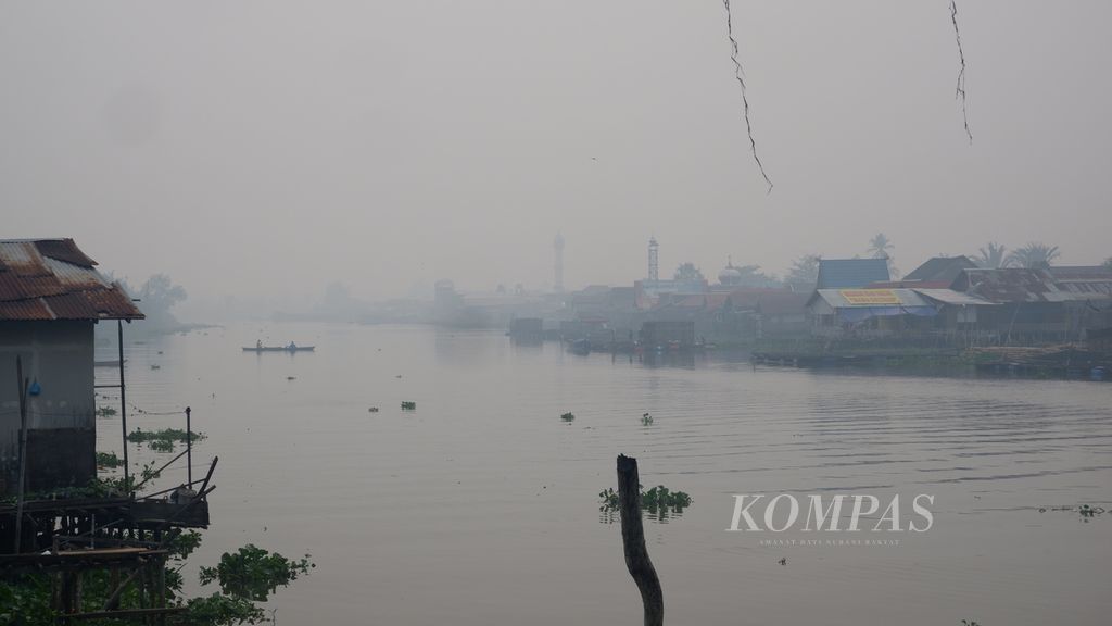 Kondisi kabut asap akibat kebakaran hutan dan lahan di Sungai Martapura, Kota Banjarmasin, Kalimantan Selatan, pada Selasa (3/10/2023) pagi. Kabut asap membuat udara di Banjarmasin sangat tidak sehat.