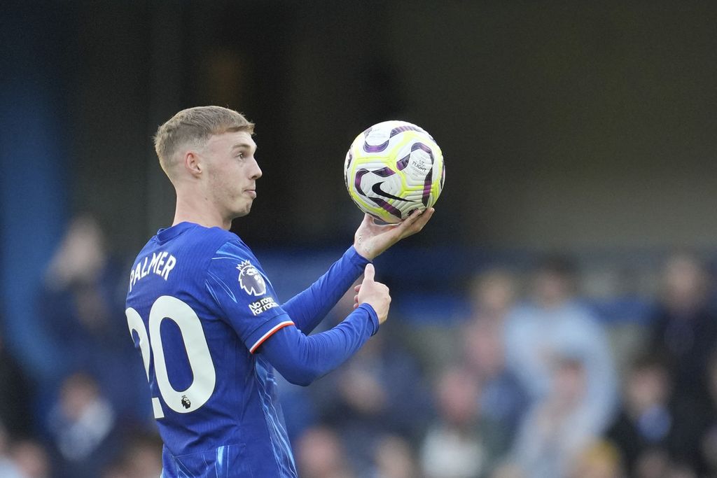 Pemain Chelsea, Cole Palmer, membawa bola pertandingan keluar lapangan seusai laga sebagai tanda telah mencetak tiga gol atau lebih saat melawan Brighton di Stamford Bridge, London, Sabtu (28/9/2024). Palmer mencetak semua gol Chelsea yang menang dengan skor 4-2.  