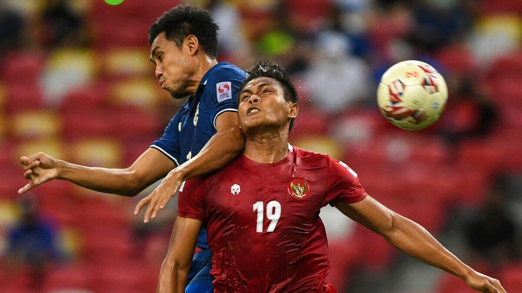 Pemain Thailand, Teerasil Dangda (kiri), berebut bola dengan pemain Indonesia, Fachruddin Wahyudi Aryanto, dalam laga kedua final Piala AFF yang digelar di Stadion Nasional, Singapura, Sabtu (1/1/2022). Pada laga kedua, Indonesia menahan imbang Thailand, 2-2, sehingga Thailand unggul agregat gol 6-2.