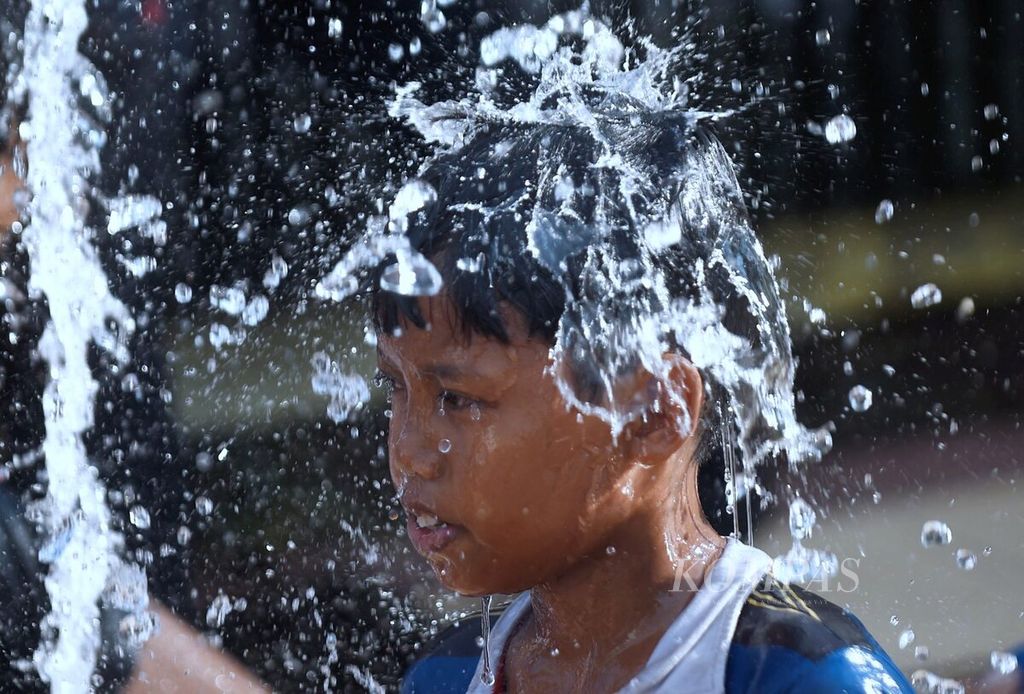 Anak-anak bermain di air mancur di sekitar Tugu Pahlawan, Surabaya, Senin (1/5). Aktivitas tersebut untuk mengurangi dampak cuaca panas yang terjadi beberapa hari terakhir.