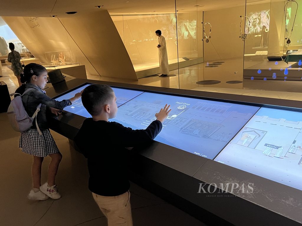 Dua anak tengah bereksplorasi dengan media interaktif di National Museum of Qatar.