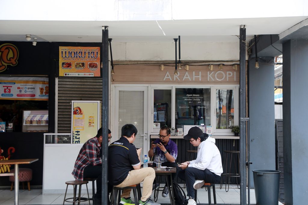 Warga berbincang di salah satu gerai kopi di Jalan Kyai H Syahdan, Jakarta Barat, Senin (14/11/2022). 