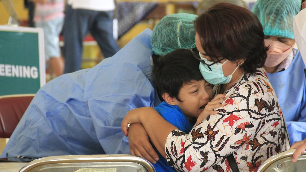 Orangtua menenangkan anaknya yang diukur tekanan darahnya sebagai syarat menerima suntikan vaksin Covid-19 di Gedung Sasono Hinggil Dwi Abad, Yogyakarta, akhir Desember 2021.