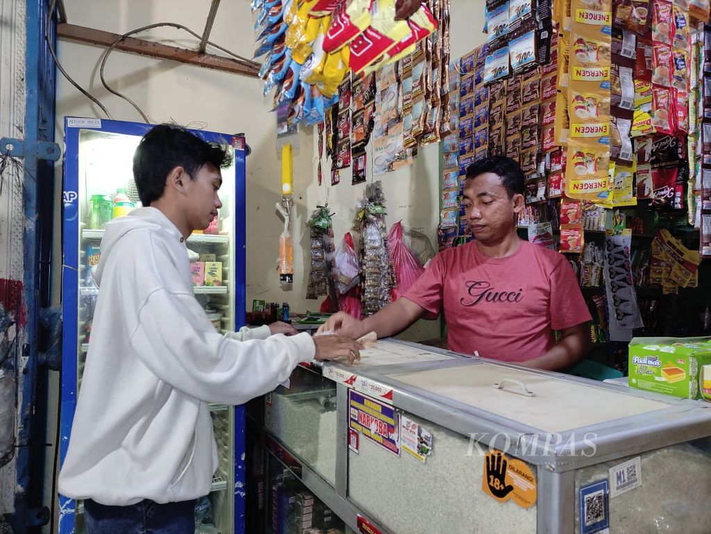 Ari Wahyudi (kanan) melayani pembeli di warung madura yang telah berdiri lebih dari lima tahun di Sawangan, Depok, Jawa Barat, Rabu (9/11/2022). Yudi adalah pengelola warung madura milik Abdul Hamied. 