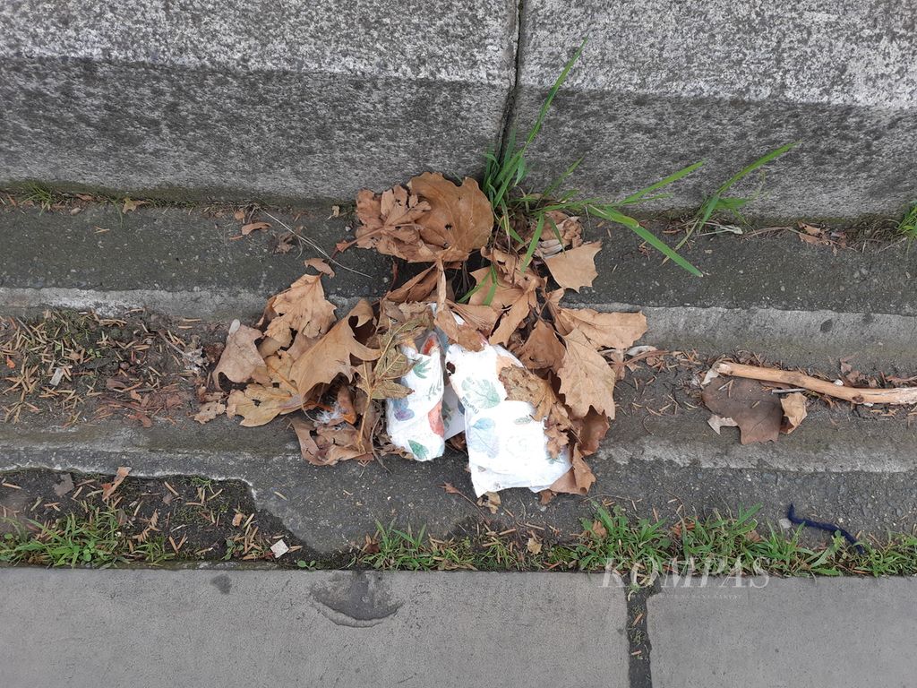 Bekas popok bayi dibuang di jalur pedestrian Albert Embankment, sisi Sungai Thames, London, Inggris, Minggu (26/11/2023). Banyak sampah bertebaran di jalur tersebut.