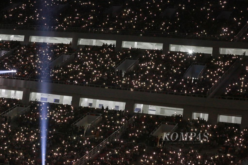 Nyala lampu dari telepon seluler penonton yang menghadiri puncak perayaan hari ulang tahun (HUT) ke 495 DKI Jakarta di Jakarta International Stadium (JIS), Jakarta Utara, Sabtu (25/6/2022) malam. 