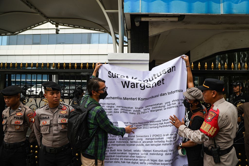 Peserta aksi membawa spanduk tuntutan dalam aksi geruduk Kominfo di depan kantor Kementerian Komunikasi dan Informatika, Jakarta, Rabu (10/7/2024). 