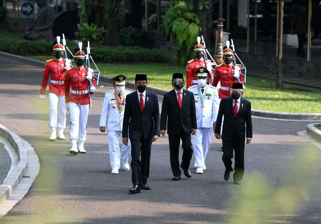 President Joko Widodo and Vice President Ma'ruf Amin walk together with Jambi Governor Al Haris and Jambi Deputy Governor Abdullah Sani, before the inauguration ceremony at the State Palace, Jakarta, Wednesday (7/7/2021).