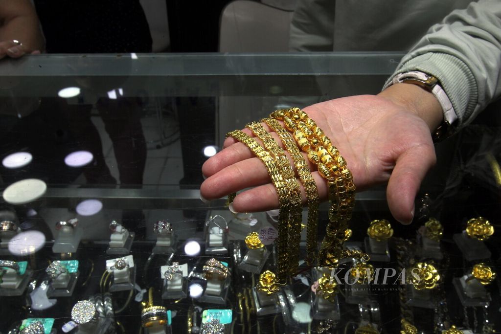 Karyawan toko emas melayani konsumen memilih perhiasan emas di toko penjualan emas di Cikini Gold Center, Jakarta, Kamis (4/7/2019). 