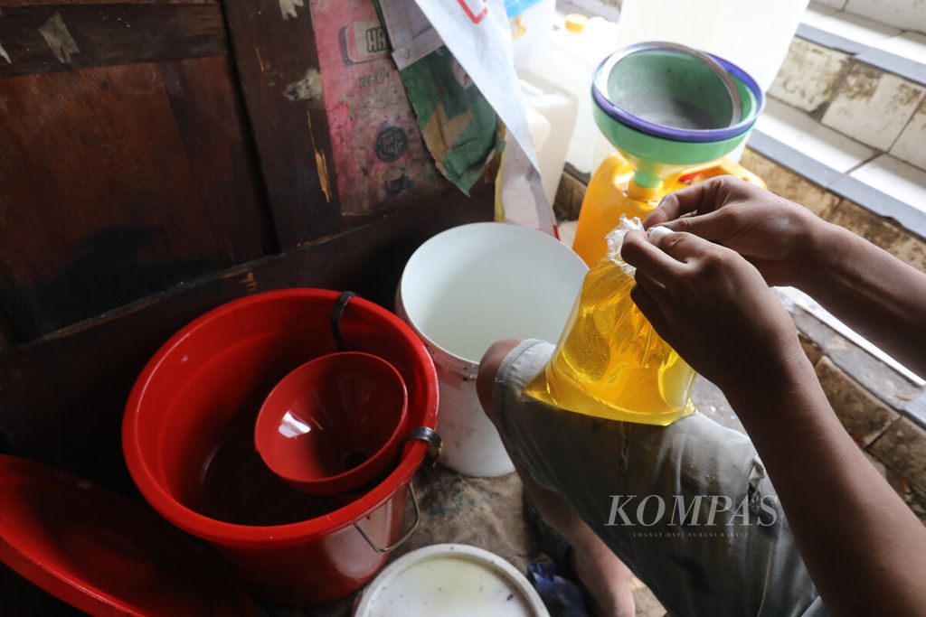 Pedagang mengemas minyak goreng curah ke dalam plastik kemasan di Pasar Induk Kramat Jati, Jakarta, Selasa (28/6/2022).