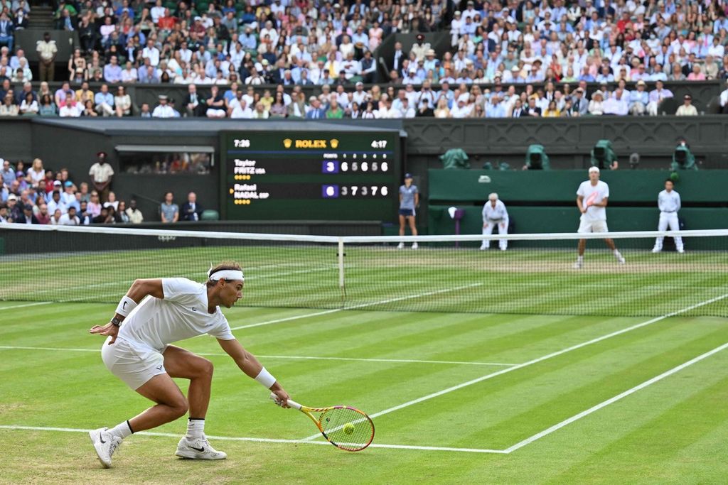 Petenis Spanyol Rafael Nadal mengembalikan bola ke petenis AS Taylor Fritz pada laga perempat final Wimbledon di All England Club, London, Inggris, Rabu (6/7/2022) sore waktu setempat atau Kamis dinihari WIB. Nadal menang dengan skor 3-6, 7-5, 3-6, 7-5, 7-6 (10-4). 