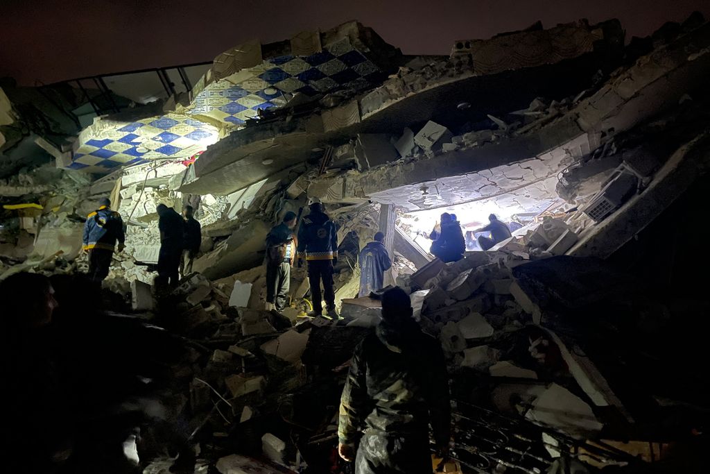 Petugas penyelamat Suriah (Helm Putih) dan warga mencari para korban dan penyintas di antara reruntuhan bangunan akibat gempa yang mengguncang Provinsi Idlib yang berbatasan dengan Turki, 6 Februari 2023. 