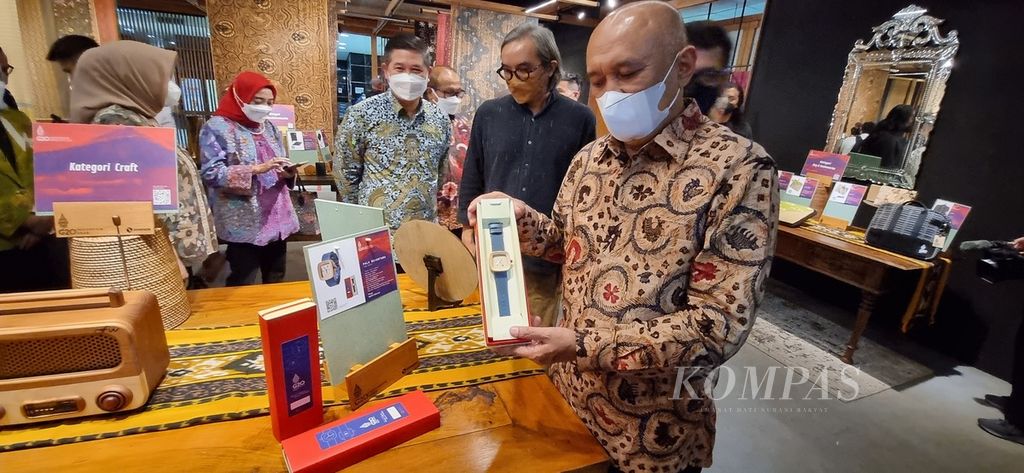 Sebanyak 20 produk usaha kecil menengah (UKM) berhasil terkurasi menjadi produk resmi presidensi G20 oleh Kementerian Koperasi dan UKM. Menteri Koperasi dan UKM Teten Masduki (kanan) memperlihatkan produk UKM yang lolos kurasi di Smesco Indonesia, Jakarta, Selasa (26/7/2022). 