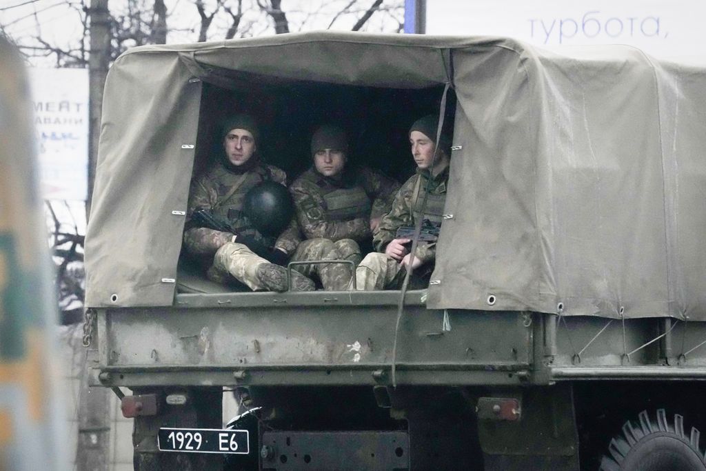 Tentara Ukraina menumpang kendaraan militer di Mariupol, Ukraina, Kamis (24/2/2022). Pasukan Rusia meluncurkan serangan ke Ukraina pada Kamis, ketika Presiden Vladimir Putin mengesampingkan kecaman dan sanksi internasional, memperingatkan negara-negara lain bahwa segala upaya untuk mengganggu akan menyebabkan konsekuensi.