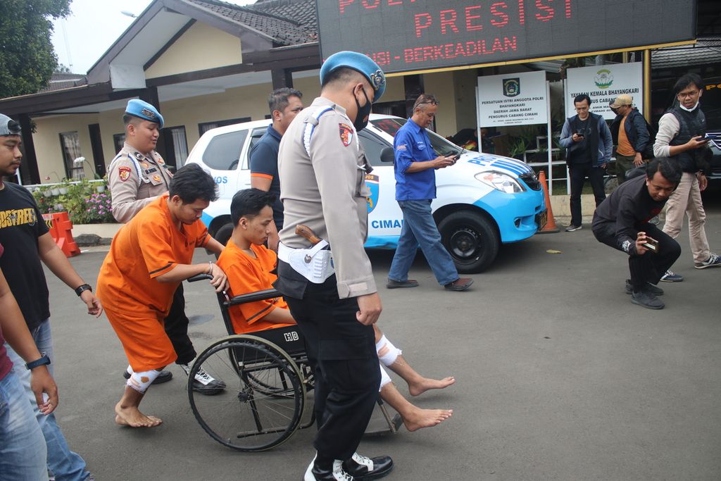 GS (di kursi roda) dan AB digiring sejumlah polisi di Markas Kepolisian Resor Cimahi, Jawa Barat, Rabu (8/2/2023). Mereka berdua ditangkap karena melakukan penganiayaan dan ditembak petugas karena dianggap melakukan perlawanan.